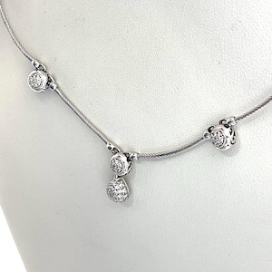 May include: A silver-toned cable chain necklace featuring three distinct stations. Two stations are circular charms encrusted with small clear stones, while the central station features a circular charm with a dangling teardrop-shaped pendant.