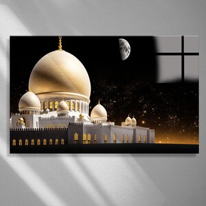 Op de afbeelding: Digitale kunstprint van een moskee met een grote gouden koepel en kleinere koepels. De moskee is wit met gouden accenten, tegen een sterrenhemel met een halve maan. De afbeelding heeft een dramatisch, verlicht effect.