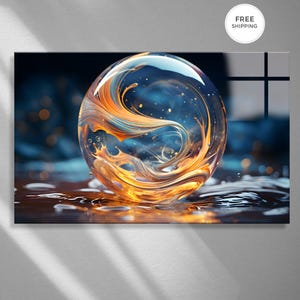 May include: A glass art piece featuring a large, clear sphere with swirling orange and blue internal designs. The sphere appears to be resting on a reflective surface, with water droplets and a dark blue background.