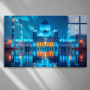 May include: A stunning, illuminated mosque with multiple domes and minarets, reflecting in the water below. The architecture is bathed in blue light, with accents of gold and orange. The sky is a deep blue with dramatic cloud formations.