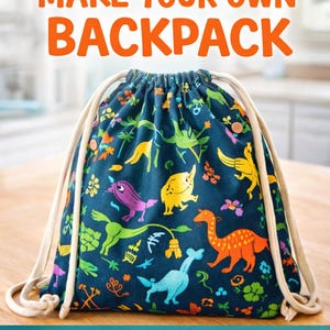 May include: A dark blue drawstring backpack featuring a colorful pattern of various dinosaurs and small flowers. The bag has thick white rope straps and two small wooden buttons on the front. Text reads: KIDS LEARN TO SEW MAKE YOUR OWN BACKPACK PRE-CUT & BEGINNER FRIENDLY NO CUTTING REQUIRED.