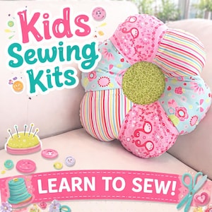 Op de afbeelding: Een bloemvormige naaiset voor kinderen, met roze, blauwe en groene stoffen met bloemen- en streepmotieven. De tekst "Kids Sewing Kits" en "Learn to Sew!" is zichtbaar, wat het leren naaien stimuleert.