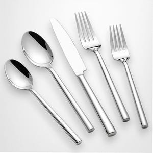 Può includere: Un set di posate in acciaio inossidabile lucido, tra cui due cucchiai, un coltello e due forchette. Le posate hanno un design semplice e moderno con manici lunghi e sottili e una superficie riflettente, perfette per una cena formale.