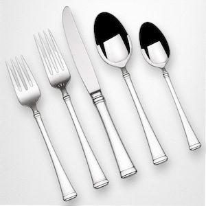 Può includere: Un set di posate lucide, tra cui due forchette, un coltello e due cucchiai. Le posate hanno un design semplice ed elegante con una superficie liscia e riflettente. Gli utensili sono disposti diagonalmente su uno sfondo bianco.