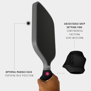 May include: A gray and black pickleball paddle with the text "OPTIMAL PADDLE FACE TOPSPIN FACE POSITION". The image also shows a black grip with the text "ADJUSTABLE GRIP SETTING FOR: CONTINENTAL EASTERN SEMI WESTERN". A black grip cover is also shown.