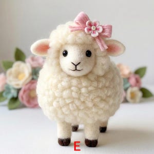 May include: A handcrafted, fluffy white sheep figurine with a pink bow and flower on its head. The sheep has black eyes, pink ears, and brown hooves. The letter "E" is visible on the bottom. The background features soft-focus flowers.