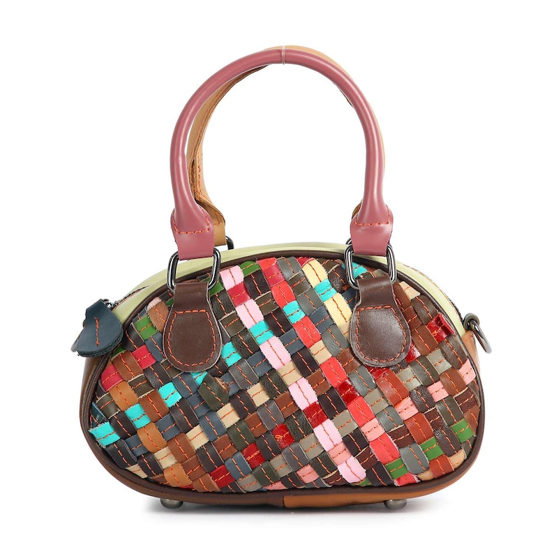 May include: A colorful, woven leather handbag with a rounded shape. The bag features a variety of colors, including red, blue, brown, and pink, in a basketweave pattern. It has a pink handle and brown leather accents, with a small blue leather tag.