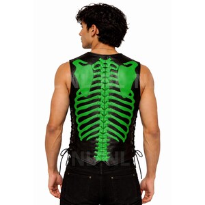 May include: Black leather vest with a neon green skeleton design on the back. The vest has a lace-up closure on the sides. The skeleton design includes the spine and shoulder blades. The vest is sleeveless.
