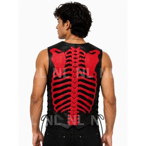 May include: Black leather vest with a red skeleton design on the back. The vest has a round neck and lace-up sides. The skeleton design includes the rib cage and shoulder blades.