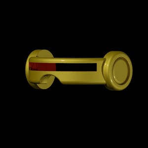 May include: A gold-colored, cylindrical object with a rectangular black and red section in the center. The object has rounded ends and a curved handle-like design on one side, set against a black background.