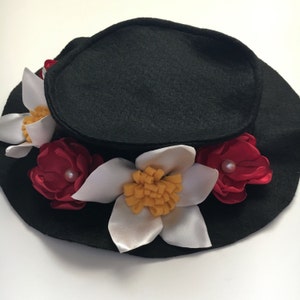 May include: A black felt hat with white and red felt flowers. The flowers have yellow centers and pearl accents.