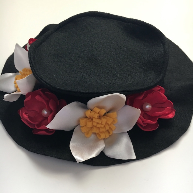 May include: A black felt hat with white and red felt flowers. The flowers have yellow centers and pearl accents.