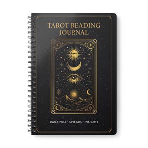 Può includere: Un diario nero a spirale con dettagli dorati. La copertina presenta il testo "TAROT READING JOURNAL" sopra un'illustrazione dettagliata di simboli celesti. La parte inferiore della copertina recita "DAILY PULL • SPREADS • INSIGHTS".