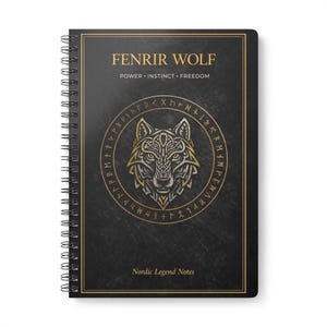 Könnte beinhalten: Ein schwarzes Spiralnotizbuch mit goldenem Schriftzug "FENRIR WOLF" und "POWER INSTINCT FREEDOM". Das Cover zeigt eine detaillierte Wolfsillustration in einem Kreis und die Worte "Nordic Legend Notes".