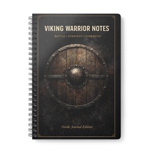 May include: A spiral-bound notebook with the title "VIKING WARRIOR NOTES" and the words "BATTLE • STRATEGY • STRENGTH" printed on the cover. The cover features a detailed illustration of a wooden shield. The words "Nordic Journal Edition" are printed at the bottom.