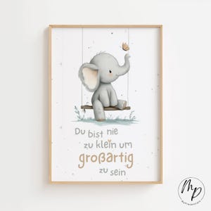 May include: A framed print with a cartoon elephant on a swing, with a butterfly above its trunk. The text reads "Du bist nie zu klein um großartig zu sein". The artwork is in a light wood frame, suitable for a nursery or child's room.