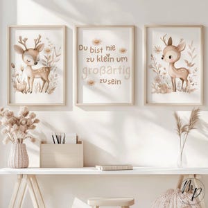 May include: Three framed art prints with fawn and floral illustrations in beige and brown hues. One print features German text: "Du bist nie zu klein um großartig zu sein."