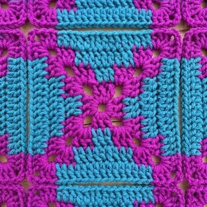 May include: A series of interconnected square crochet motifs featuring a vibrant color scheme of bright magenta and turquoise blue yarn. The pattern consists of repeating stitches arranged in a geometric grid, creating a textured fabric surface.