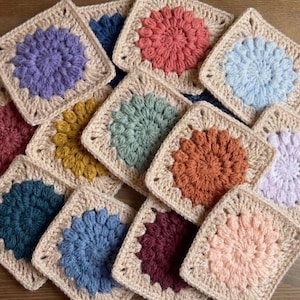 以下が含まれることがあります： クリーム色の斑点のある釉薬が施された、3つのセラミックマグのセット。各マグには、青と緑の葉、黄色の花、赤いベリーなど、異なる手描きのデザインが施されています。マグはシンプルで丸みを帯びた形をしています。