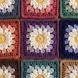 Könnte beinhalten: Nahaufnahme von neun gehäkelten Quadraten, jedes mit einem Gänseblümchen-Design. Die Quadrate sind in verschiedenen Farben gehalten, darunter Rosa, Lila, Grün und Blau, mit gelber Mitte und weißen Blütenblättern. Die Quadrate sind in einem Raster angeordnet.