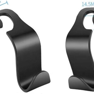 May include: Two black car seat hooks. Each hook is 11.2cm tall, 3.8cm wide at the top, and 1.45cm wide at the hook opening. The hook opening is 1.5cm. The hooks have a curved design.