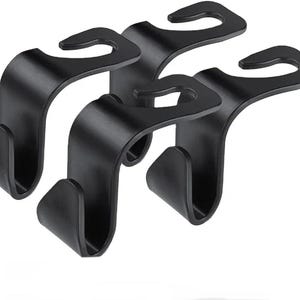 May include: Four black car seat headrest hooks. Each hook has a curved top for hanging and a lower hook for securing items. The hooks are made of a matte black material, designed for car organisation.