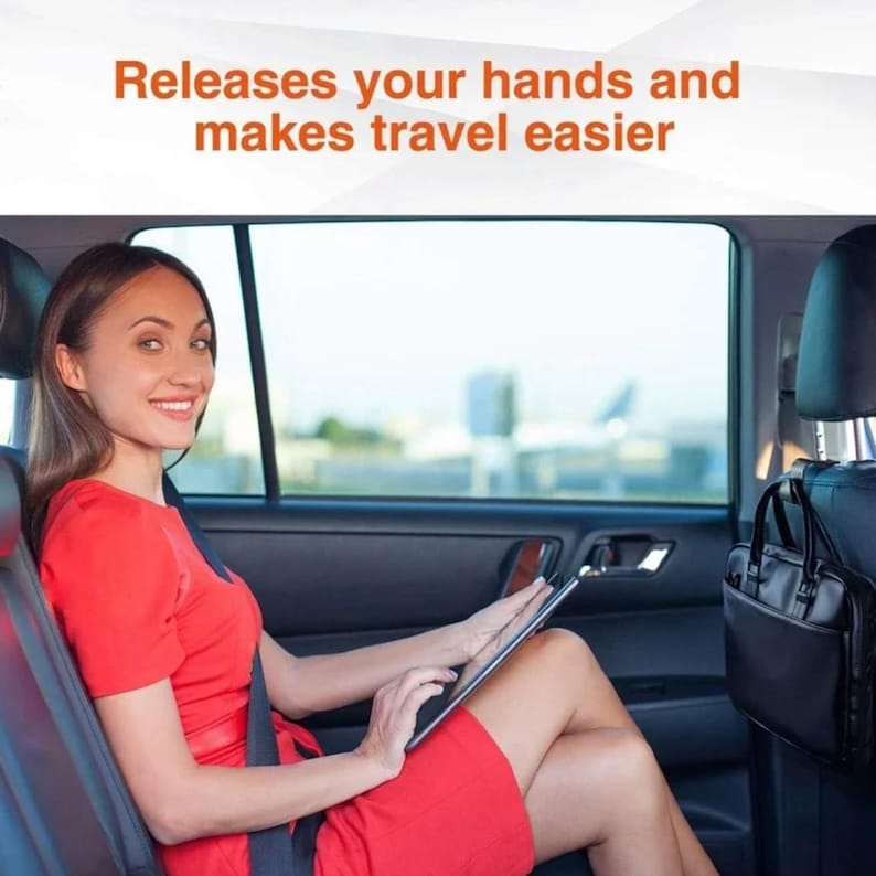 May include: A woman in a red dress sits in a car, using a tablet. The text "Releases your hands and makes travel easier" is displayed above. A black organiser is attached to the back of the front seat.