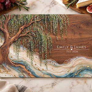 May include: A rectangular wooden cutting board featuring a painted willow tree on the left side and a swirling blue, white, and gold resin river design at the bottom. The text EMILY & JAMES and EST. 2026 is printed in white on the right.