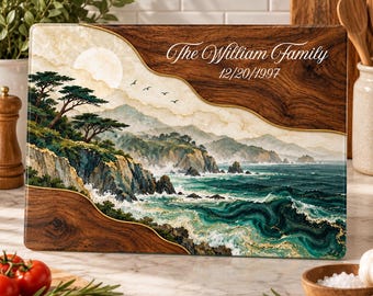Peut inclure: Une planche à découper rectangulaire en bois avec une impression de paysage côtier et une bordure en bois foncé. Le motif montre des falaises, des vagues et une lune. Le texte indique The William Family et 12/20/1997 en blanc.