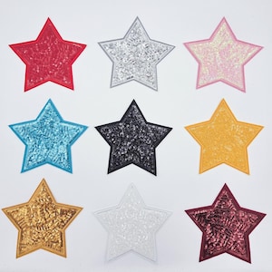 May include: Nine star-shaped sequin patches in various colors, including red, silver, pink, blue, black, yellow, gold, white, and burgundy. Each patch has a stitched border and a sequined surface, perfect for embellishing clothing or accessories.