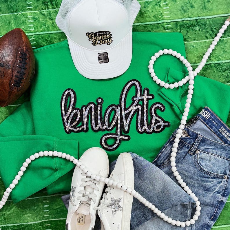 Knights Sequin Patch, a shiny and decorative patch featuring a knight emblem, displayed among athletic clothing and accessories.