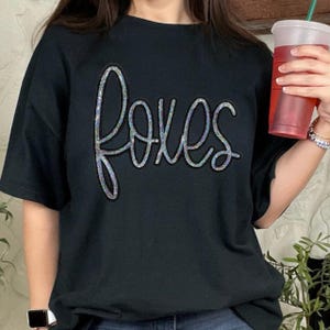 Foxes Sequin Patch, black t-shirt with the word 'foxes' in colorful sequins.