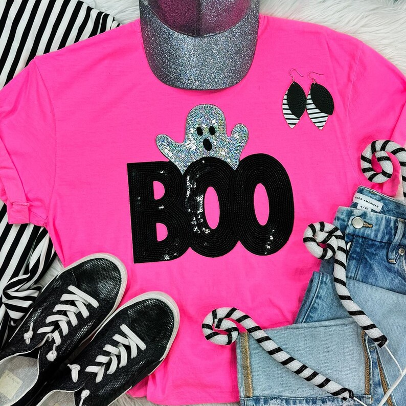 Sequin Boo Ghost Patch, a sparkling ghost patch design displayed on a pink t-shirt with other fashion accessories.