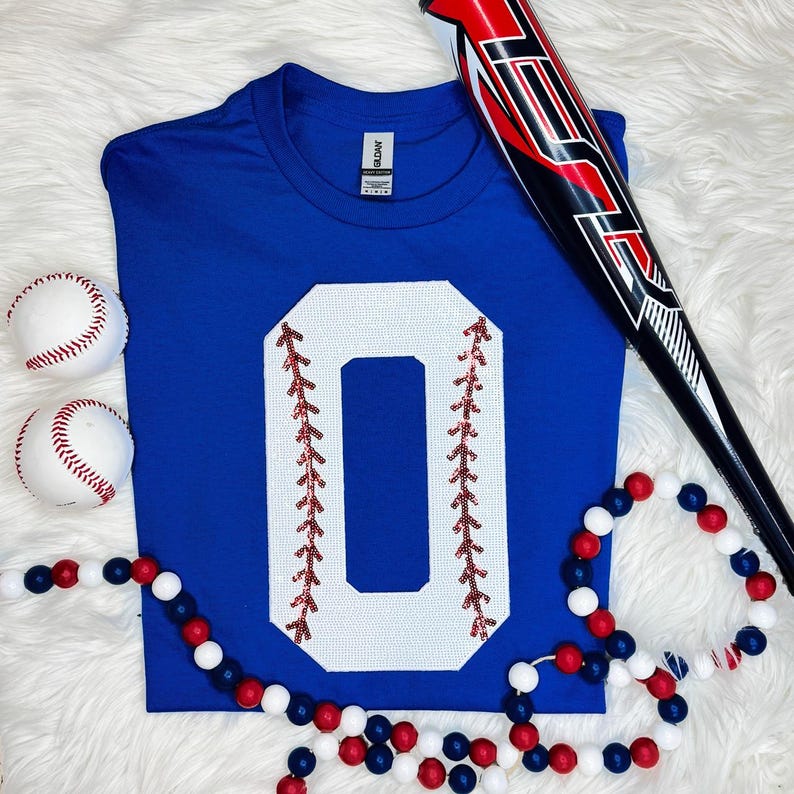 Baseball Number Sequin Patch, a white '0' sewn onto a blue T-shirt with red leaf embroidery details along the number edges.