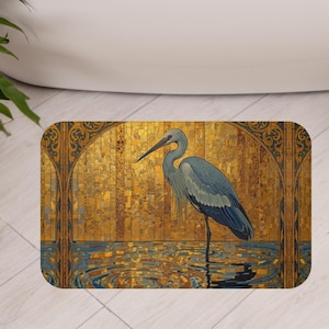 May include: Rectangular bath mat featuring a blue heron standing in water, set against a gold mosaic background with arch details. The mat has a blue and gold color scheme, with a decorative border.