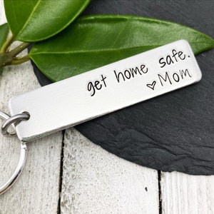 May include: Silver keychain with the text "get home safe. ♥ Mom" engraved on it.