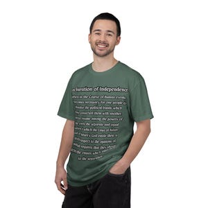 May include: A green t-shirt with the text "Declaration of Independence" and a portion of the text from the document in white. The shirt is a solid color and has short sleeves.