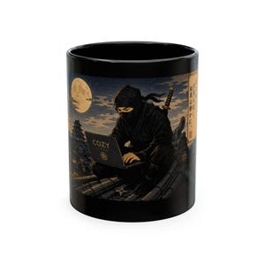 May include: A black ceramic mug featuring a graphic illustration of a ninja in dark clothing sitting on a tiled roof at night, using a laptop with the text COZY JAPAN. A full moon, a castle silhouette, and Japanese text are visible in the background.