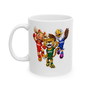 Puede incluir: Taza de cerámica blanca con tres mascotas de dibujos animados: un alce en rojo, un jaguar en verde y un águila en azul. Las mascotas sonríen y saludan. La taza tiene un asa blanca y un acabado brillante.