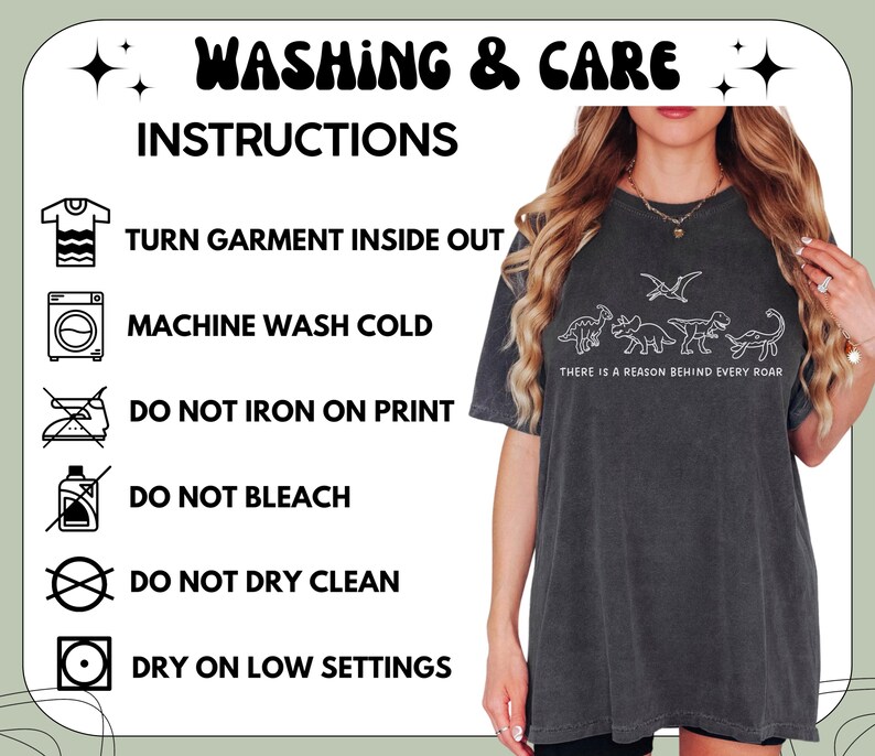 May include: A charcoal gray t-shirt featuring a white line-art graphic of four dinosaurs and the text "THERE IS A REASON BEHIND EVERY ROAR." The image includes a washing and care instruction chart with icons for turning inside out, cold wash, no bleach, no dry clean, low heat dry, and no ironing on the print.