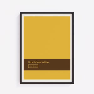 May include: A framed art print with a solid Hawthorne Yellow colour block design. A dark brown horizontal band displays the text "Hawthorne Yellow" and the hex code #e5b738. The artwork is encased in a black frame.