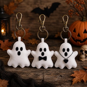 Puede incluir: Tres llaveros de fantasma hechos de fieltro blanco con mosquetones y anillas de color bronce. El primer fantasma es sencillo, el segundo lleva una pajarita negra y el tercero luce un collar de cordón negro con un pequeño corazón negro.