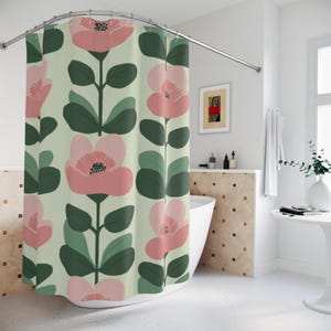 May include: A floral shower curtain featuring a repeating pattern of large pink flowers with dark green leaves and stems against a light green background. The curtain hangs from a curved, silver-colored shower rod.