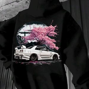 May include: Black hoodie featuring a white sports car graphic with a cherry blossom tree and Japanese-style architecture. The car has a spoiler and custom wheels. The design is set against a black and white background.
