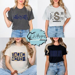 Peut inclure: Quatre t-shirts avec le texte "Sabercats" dans différents designs. Les chemises sont en charbon de bois, gris, beige et noir. Les motifs comprennent une écriture manuscrite, un "S" à imprimé léopard et des lettres en blocs. Les chemises sont portées par différentes personnes.