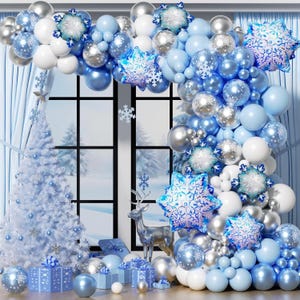 May include: A balloon arch featuring a mix of light blue, white, and metallic silver balloons, accented with large foil snowflake balloons. The arrangement is displayed around a window frame, accompanied by a white Christmas tree and gift boxes.