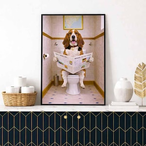 Könnte beinhalten: Ein gerahmter Druck, der einen Basset Hound auf einer Toilette zeigt, der eine Zeitung liest. Der Hund hat braunes und weißes Fell und befindet sich in einem Badezimmer. Die Zeitung trägt den Text "Behmits Its Lo Vessos".