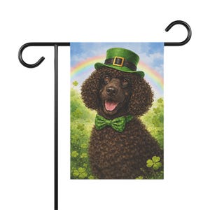 May include: A St. Patrick's Day garden flag featuring a brown poodle wearing a green hat and bow tie. The dog is set against a backdrop of a rainbow and shamrocks.