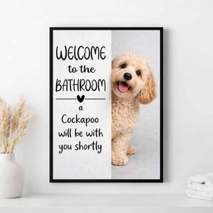 Może przedstawiać: Oprawiony obraz z psem Cockapoo i napisem "WELCOME to the BATHROOM a Cockapoo will be with you shortly". Pies jest jasnobrązowy i wydaje się szczęśliwy. Tekst jest czarny.