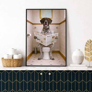 May include: Framed print featuring a dog sitting on a toilet, reading a newspaper. The dog has brown and white spotted fur. The bathroom has white tile walls and a small painting. A basket of toilet paper is in the foreground.